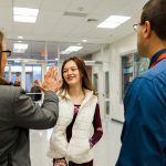 7:15 a.m. — Baker gives a high-five greeting to one of the students, as Angelo observes. She individually greets each student as they arrive, asking about their day and sharing anecdotes with Angelo. (Photo credit: Cat Boyce/Neag School)