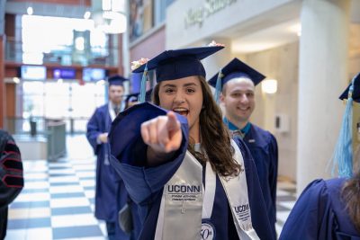 A Class of 2018 Neag School student heads out of the Gentry Building with fellow graduates on their way to the Undergraduate Commencement ceremony on May 6, 2018. (Photo credit: Frank Zappulla/Neag School)