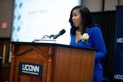 Deidra Fogarty ’05 (ED), ’06 MA speaks to the audience after receiving her Outstanding School Educator Award from the Neag School. (Defining Studios)