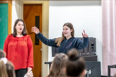 Cara Bernard, pictured on the left, looks on while Katie Cummins leads her class during the visit to UConn. (Photo credit: Frank Zappulla/Neag School)