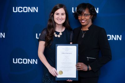Dean Gladis Kersaint, right, presents Victoria M. Schilling ’16 (ED), ’17 MA with a proclamation signed by Gov. Ned Lamont, announcing Schilling as the Neag School’s Outstanding Early Career Professional Award for 2019. (Defining Studios)