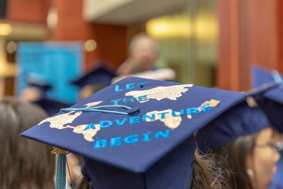 Neag School Class of 2019 grads, wearing caps with decorations they designed, prepare for their procession to the Jorgensen Center for the Performing Arts in May 2019.