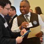 Samuel Galloway ’01 6th Year, director of human resources at Bristol Public Schools, reviews a student's resume during the Education Career Fair.