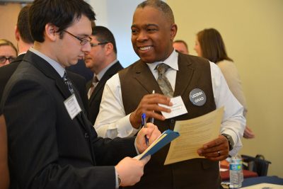 Samuel Galloway ’01 6th Year, director of human resources at Bristol Public Schools, reviews a student's resume during the Education Career Fair.
