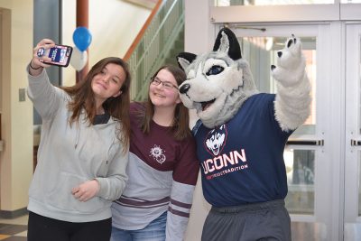 Students take a selfie with Jonathan the Husky at the Gentry Building during UConn’s Giving Day in March.