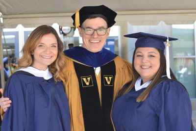 Two Neag School Class of 2019 IB/M students celebrate the completion of their master’s degree with Devin Kearns, associate professor.
