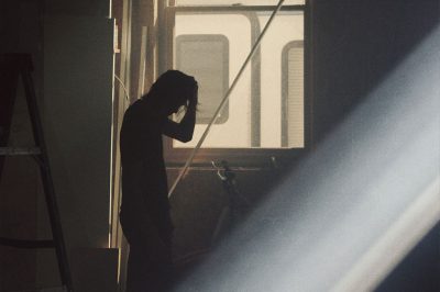 Man alone in dark hallway.