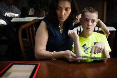A 13-year-old boy with autism, uses a keyboard and iPad to communicate with his mother.