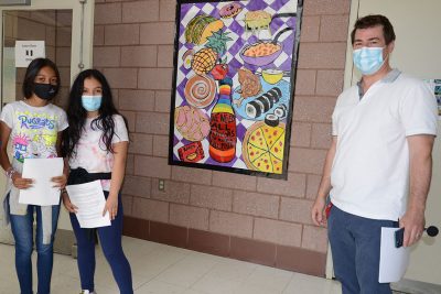 Jason Gilmore, Rogers Award winner, and two female students stand by art mural.