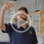 Mike Fenn holds a beaker up in the science classroom.