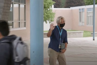 Curtis Darragh waving outside of his school on PBS News Hour.