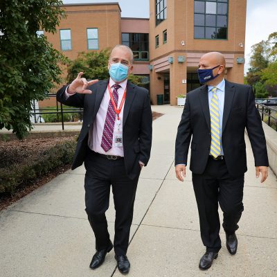 Brian Kelly and Jason Irizarry walk across NFA's campus.
