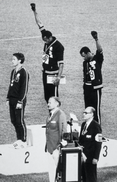 American sprinters Tommie Smith (center) and John Carlos raise their fists and give the Black Power salute during the U.S. national anthem at the 1968 Olympic Games in Mexico City. Bettmann/GettyImages