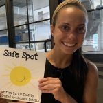 Smiling female holds book "Safe Spot"