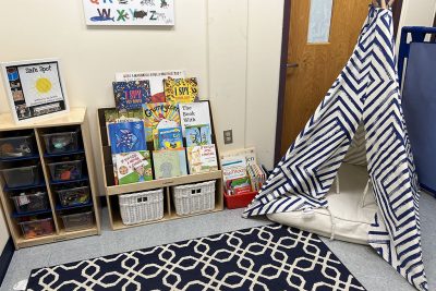 Corner of a classroom with books and small tent.