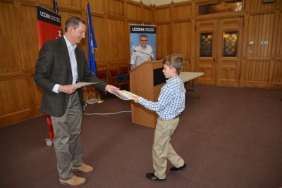 Doug Kaufman gives a certificate to one of the Letters About Literature contest winners. Jason Courtmanche stands in the background.
